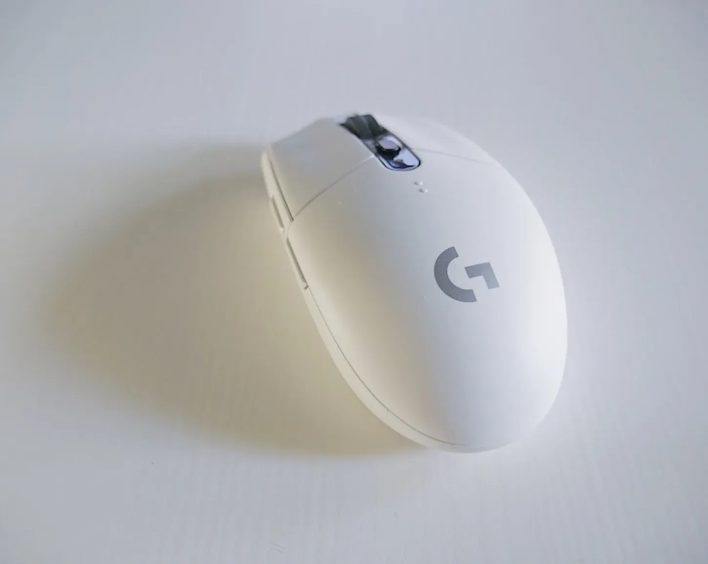 white and grey logitech g series cordless mouse on white surface